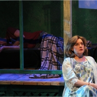 Photo of a woman sitting in front of a man on a porch