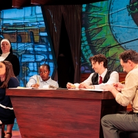 Students sitting around a table with a nun looking over them, one looks off