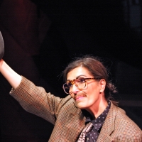 Photo of a woman portraying a man tipping their hat to someone