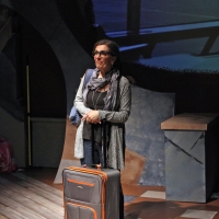 Photo of a woman standing next to a suitcase in an airport