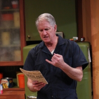 Man reading a newspaper with a grumpy look on his face