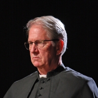 Catholic priest with glasses and a grumpy face
