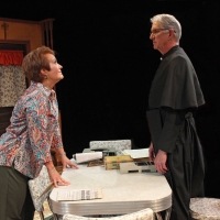 Woman leaning across a table to talk to a priest