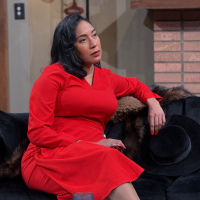 A woman wearing a red dress sitting on a couch