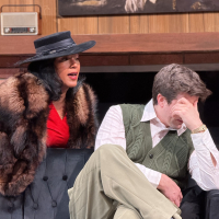 A woman wearing a hat leaning over a man covering his face, both sitting on the couch