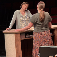 Two women facing off over a library counter