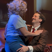 A woman sitting on a man's lap while he smiles up at her