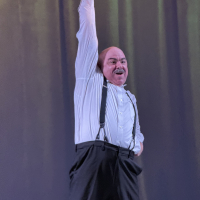 A man standing triumphantly with one arm above his head