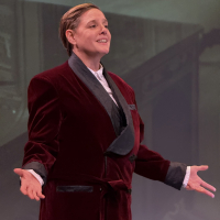 A man in a smoking jacket standing with his arms open
