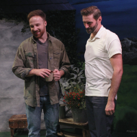 Two men standing next to each other and looking at something on a table in front of them