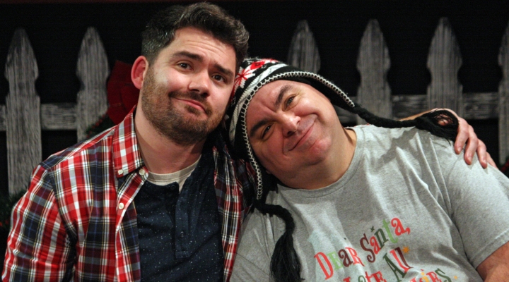 One man in a hat leaning his head on the shoulder of man with a beard