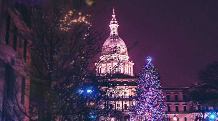 Photo of the Lansing Capitol Building with a Christmas tree in front of it