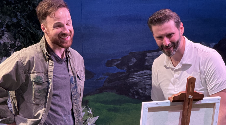 Two men looking at a piece of artwork on an easle