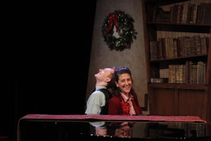 Two people laughing while sitting at a piano together